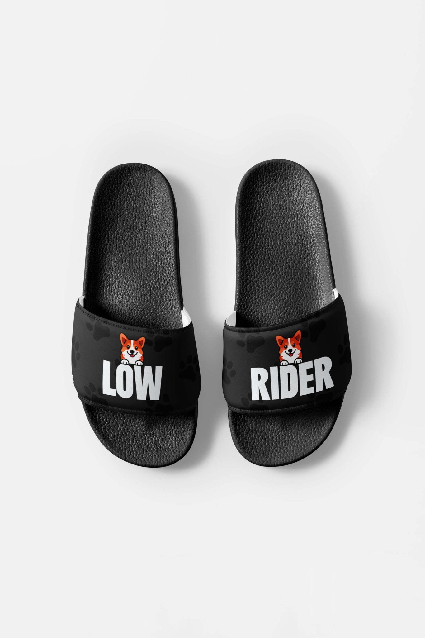 The Mighty Corgi Rider Slides from Dogloverclothing.com are black, durable sandals with LOW on the left and RIDER on the right, each displaying a small cartoon corgi face above the text.