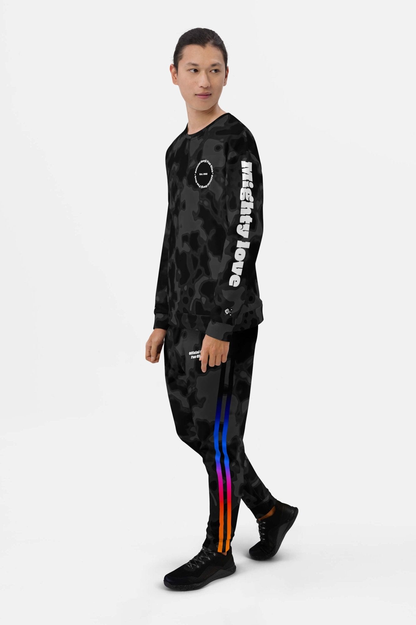 A person wears the Official Corgi Fan Club© Elite Camo Sweatshirt by Dogloverclothing.com, paired with black sneakers and colorful striped pants, standing against a plain white background.