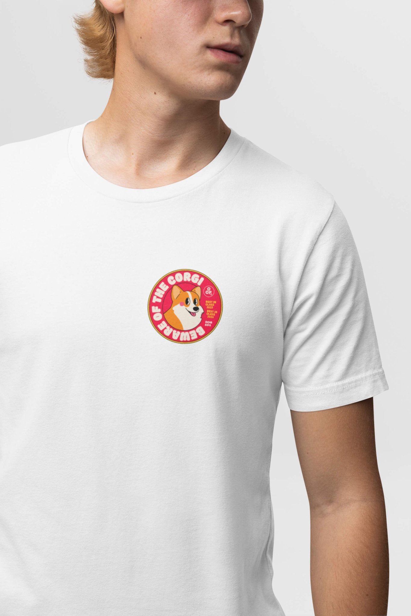 A person in a Beware of the Corgi Unisex T-Shirt by Dogloverclothing.com, showcasing ultra-comfy fabric with a red circular corgi graphic and The Corgi text, looks sideways against a grey background, embodying Corgi life.