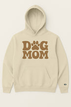 The Dog Mom Hoodie by Dogloverclothing.com is a beige hoodie with a front pocket, hood, large brown Dog Mom text, and a paw-print replacing the O in DOG.
