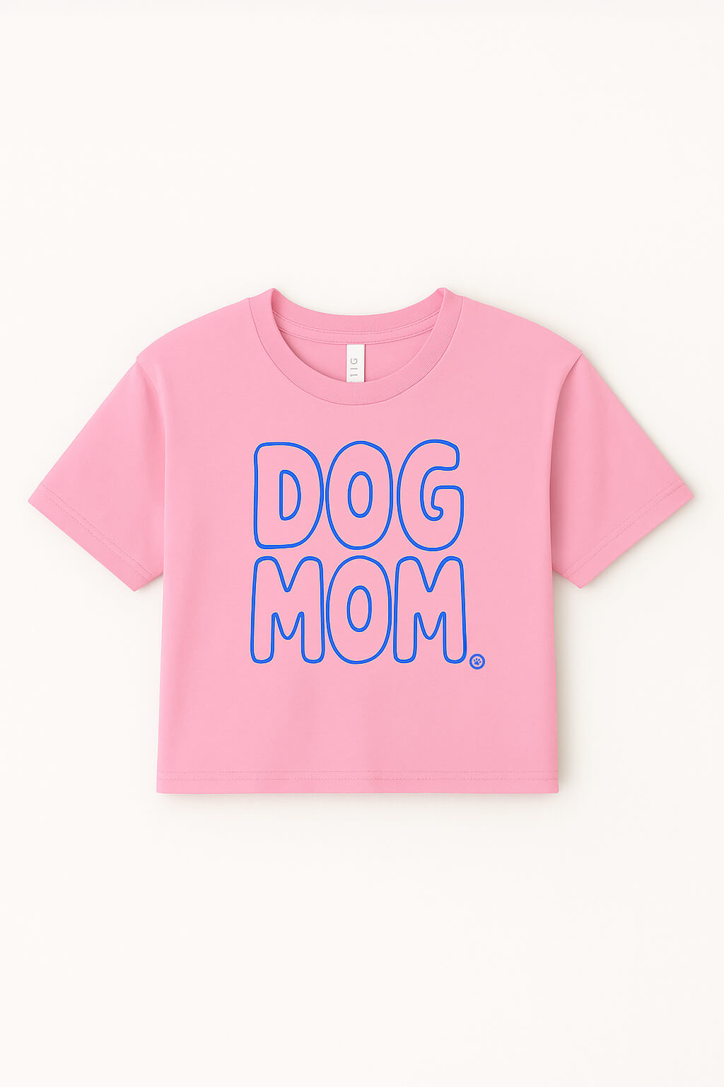 The Oversized Dog Mom Crop Top by Dogloverclothing.com is a pink, relaxed fit crop top in soft combed cotton with DOG MOM. in bold blue-outlined letters on the front, shown laid flat on a light background.