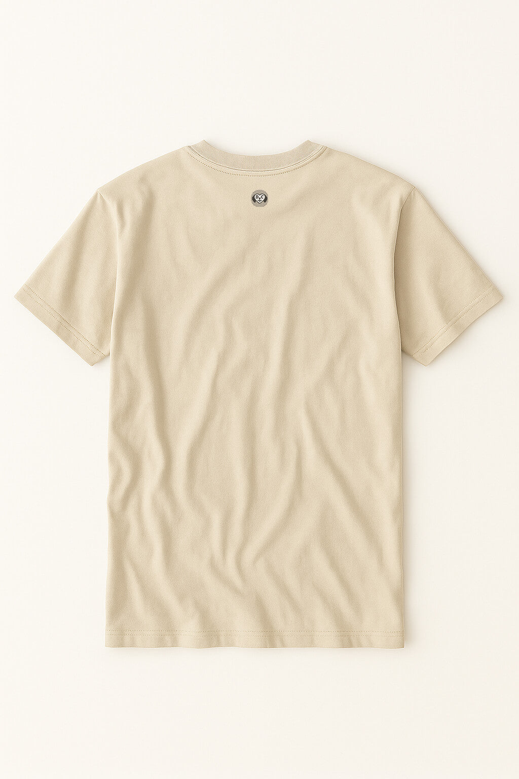 The Relaxed Dog Walker© Unisex T-Shirt from Dogloverclothing.com is a plain beige tee laid flat, back up, featuring a small circular logo near the neckline—ideal for any dog walker on a casual stroll.