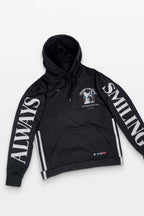 The Corgi Supreme Tribute Hoodie by Dogloverclothing.com is a black hoodie with ALWAYS SMILING in white on the sleeves. Made from recycled materials, it has a small chest graphic with text and icons, plus an eco-friendly design with drawstrings and a front pocket against a plain white background.