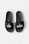 The Mighty Corgi Rider Slides from Dogloverclothing.com are black, durable sandals with LOW on the left and RIDER on the right, each displaying a small cartoon corgi face above the text.