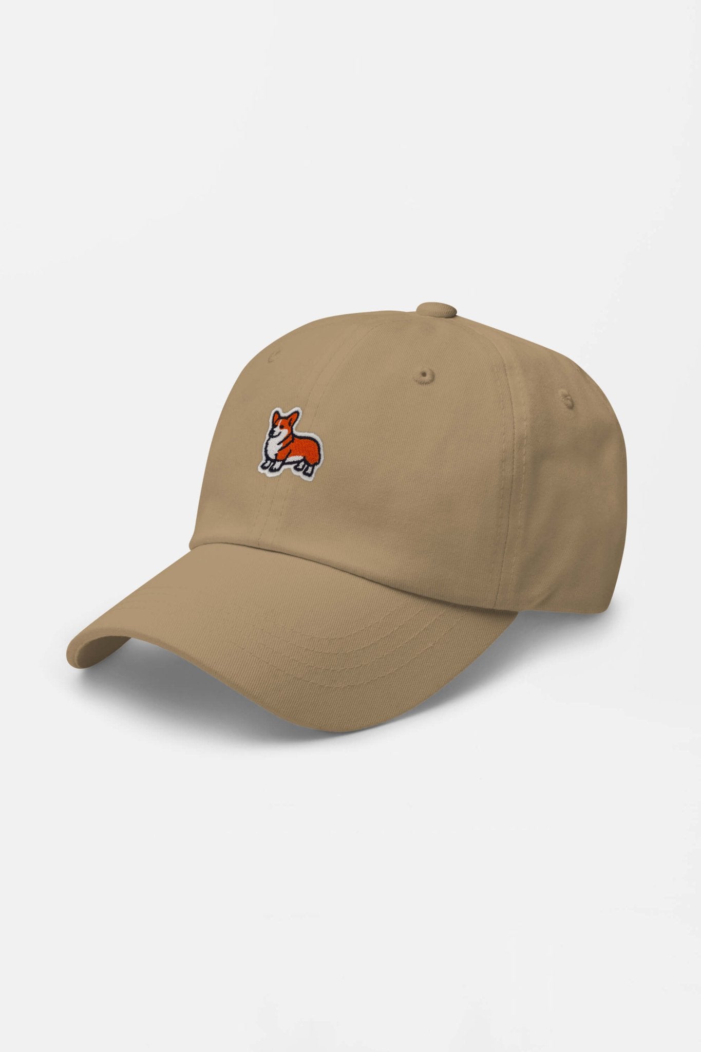 The Iconic Corgi Cap by Dogloverclothing.com is a beige hat with a small embroidered cartoon Corgi on the front, perfect for adding Corgi flair to your collection. Shown on a plain white background.