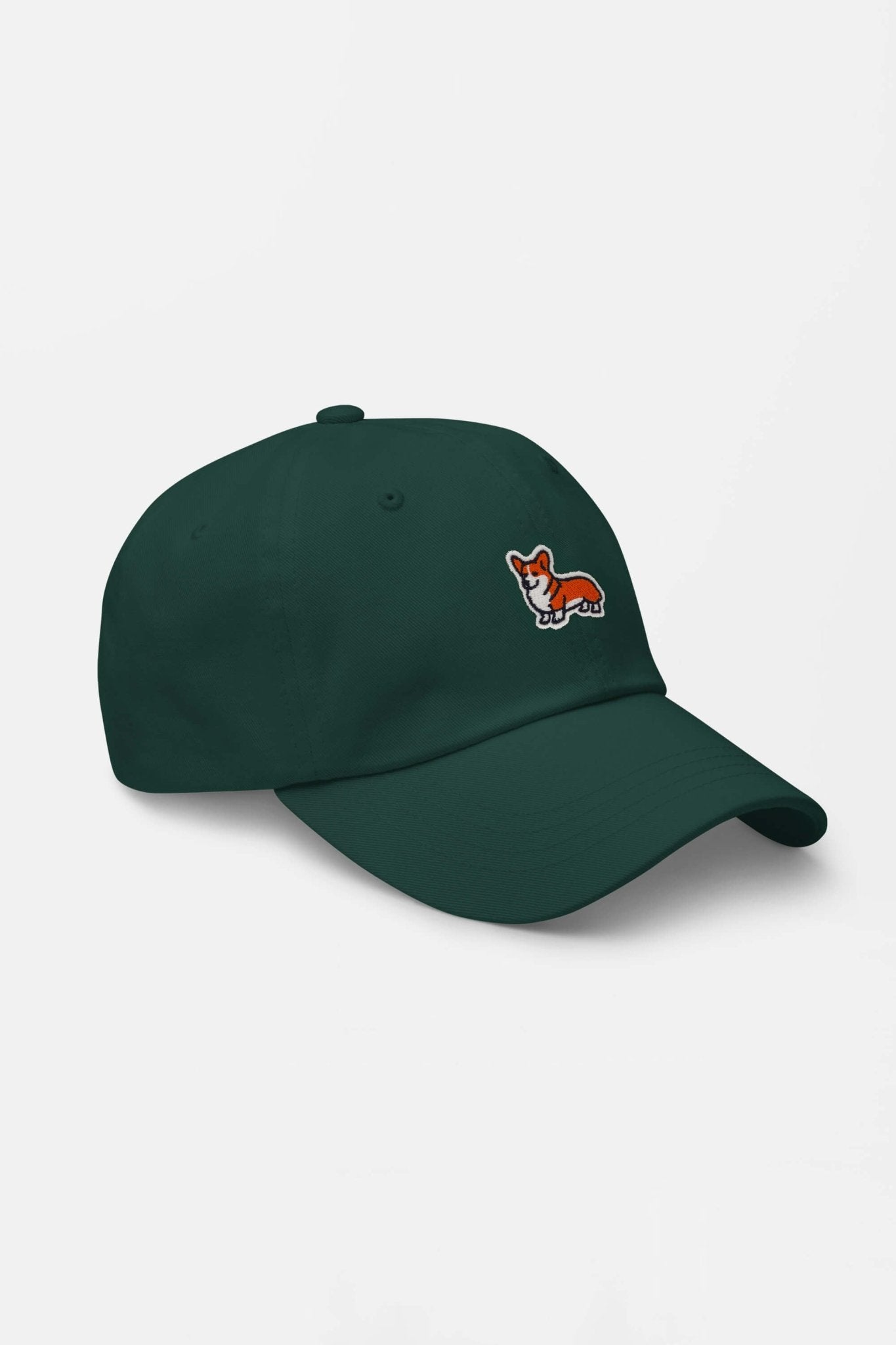 The Iconic Corgi Cap by Dogloverclothing.com is a dark green hat with a small embroidered orange and white corgi dog on the front, showcasing true Corgi cuteness. Displayed on a white background.