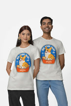 Two dog lovers smile in matching Dogloverclothing.com Best Dog Supreme Tribute Unisex T-Shirts, featuring a cartoon Corgi with Stay Awhile, Best Dog, against a plain white background.