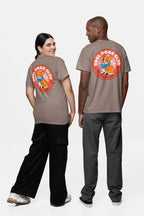 Two dog lovers, back-to-back and smiling, wear matching beige Cool Dogs Club Unisex Hype T-Shirt by Dogloverclothing.com, each adorned with a graphic of a dog in sunglasses. The left wears black pants; the right sports gray pants and black sneakers.