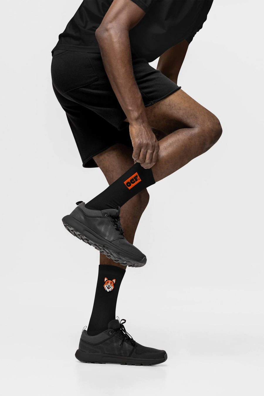 Side view of the black SOCCO x Corgi Fan Club socks from WOOF with embroidered detail