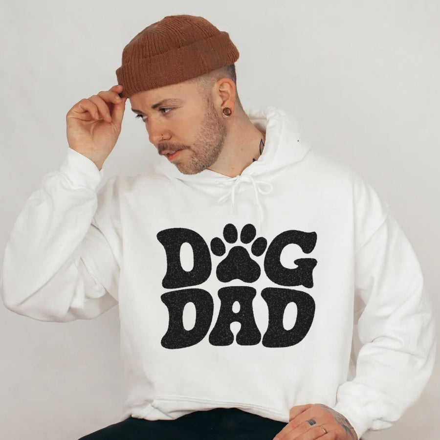 Model wearing the white Dog Dad Hoodie from WOOF with paw print lettering on the chest