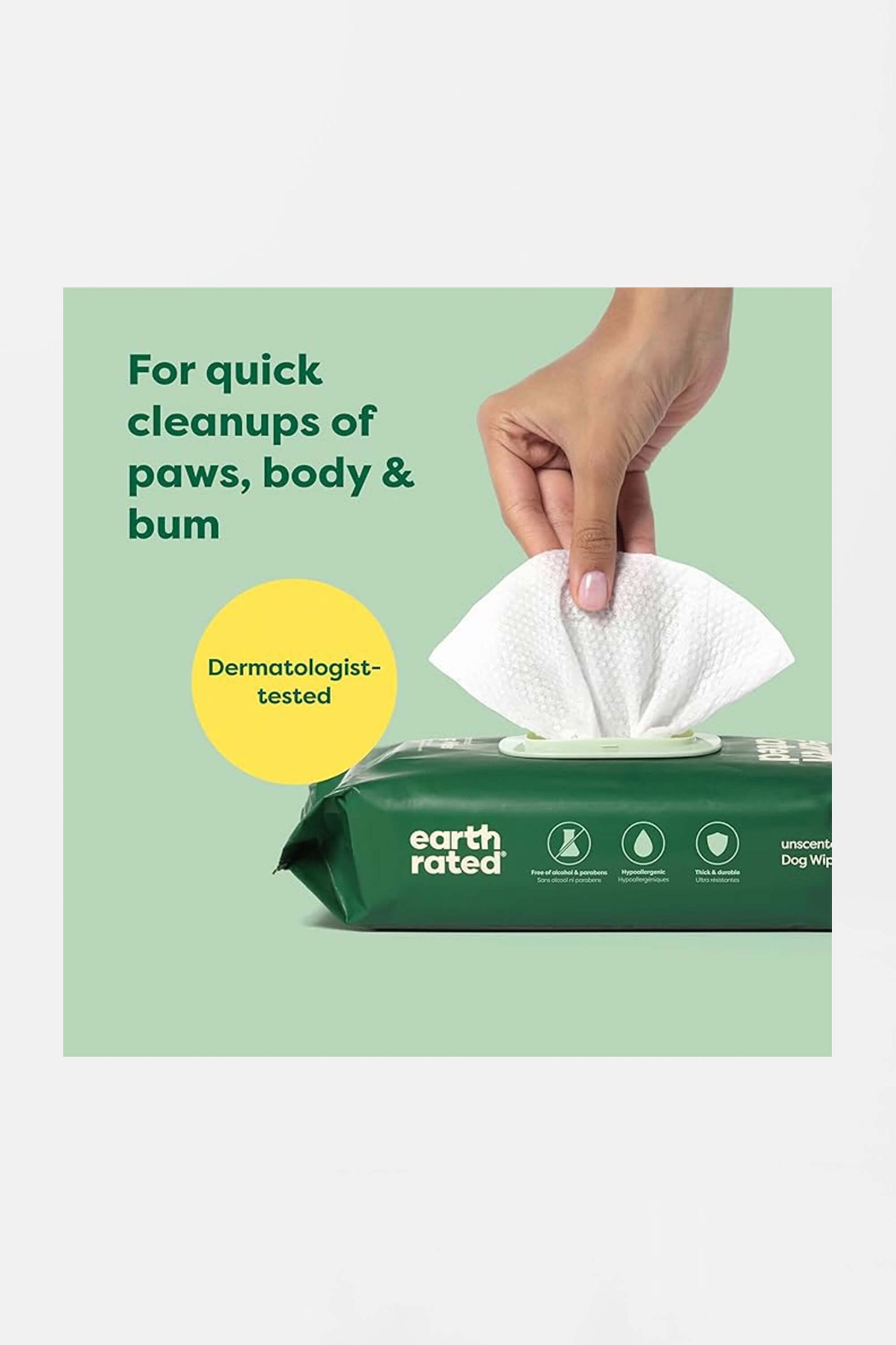 A hand pulls a white wipe from a green earth rated package. Text reads, Hypoallergenic Earth Rated Pet Wipes by Amazon: For quick cleanups of paws, body & bum, and Dermatologist-tested.