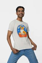 A smiling individual confidently poses against a white backdrop in a light premium cotton tee from Dogloverclothing.com. The Best Dog Supreme Tribute Unisex T-Shirt features a cartoon corgi and Best Dog text, ideal for dog lovers.
