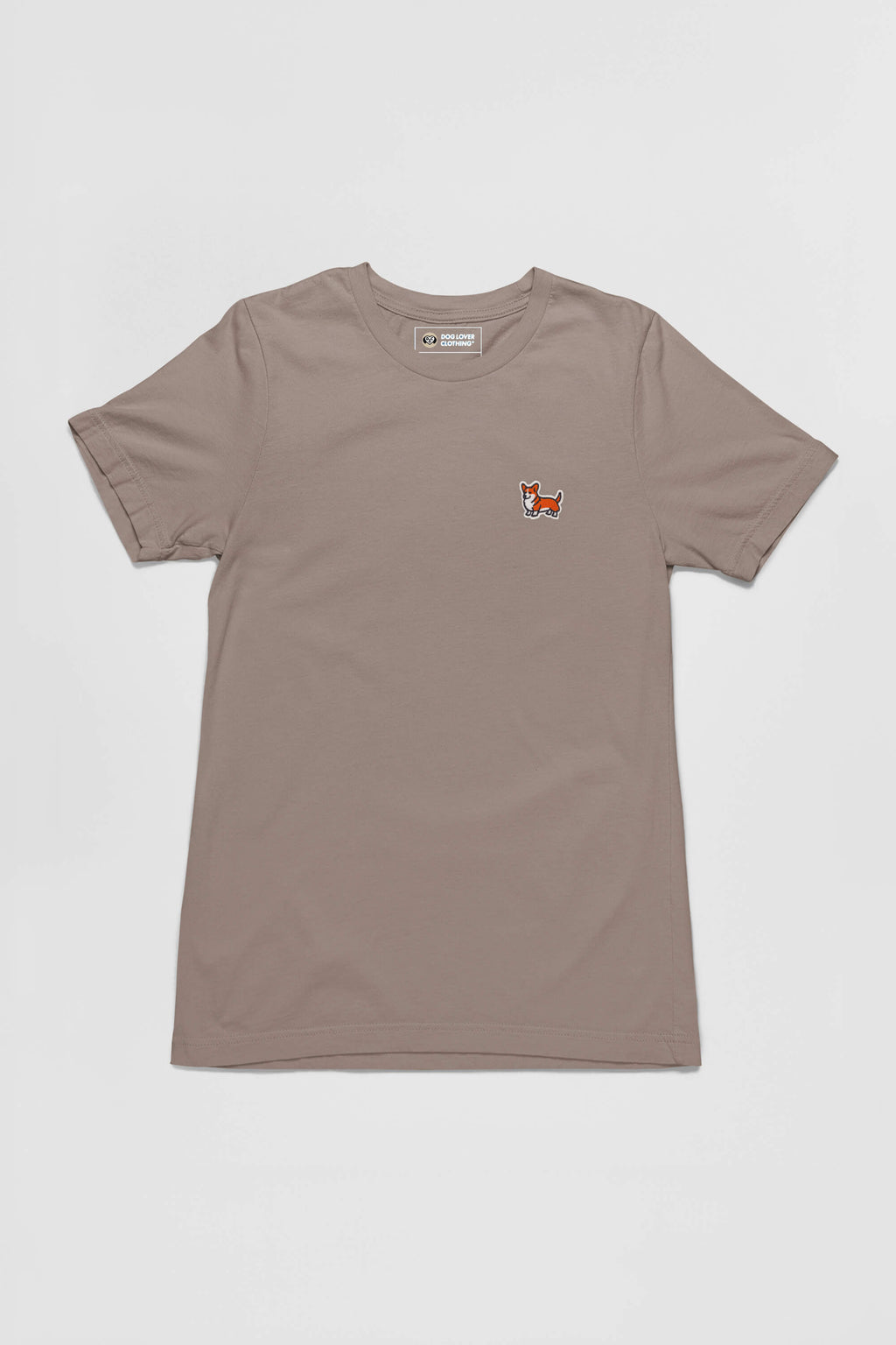 The Corgi Tail Wagger Unisex T-Shirt from Dogloverclothing.com features a small embroidered fox patch on the left chest, ideal for Corgi lovers. This taupe short-sleeved tee is set against a white background, blending simplicity with charm.