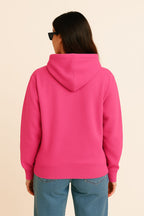 A person with long brown hair, wearing the Bold My Dog And I Talk Embroidered Hoodie from Dogloverclothing.com, blue jeans, and black sunglasses, is shown from the back against a plain light background.