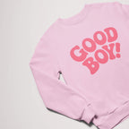 The Good Boy Sweater from Dogloverclothing.com features bold red GOOD BOY! lettering on a pink background, perfect for dog lovers.