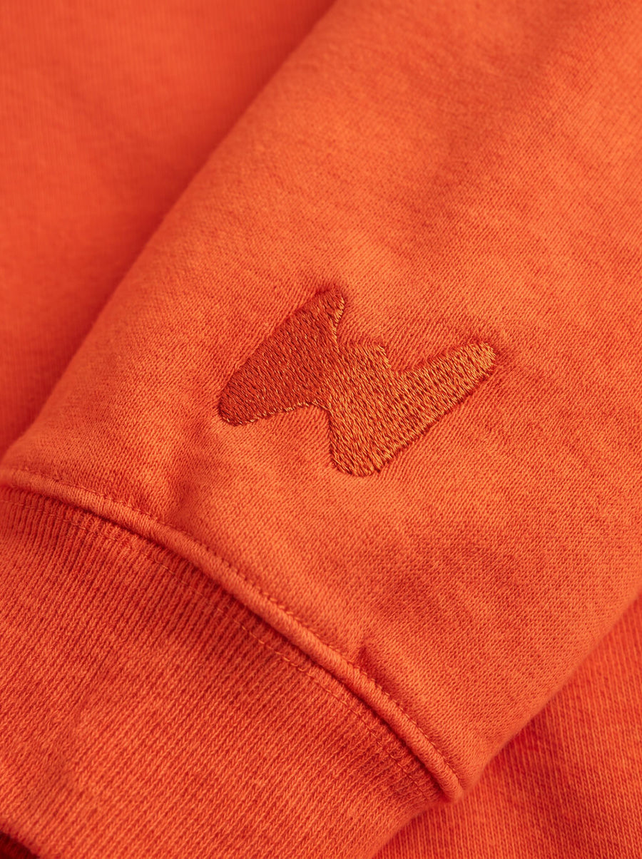 Fabric detail on the orange Dog First Statement Sweatshirt from WOOF