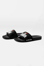The Mighty Corgi Rider Slides by Dogloverclothing.com feature black straps with RIDER in white and an orange corgi face, plus a paw print pattern. Durable and comfy, they’re ideal for dog lovers seeking stylish footwear.