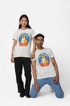 Two people confidently pose against a white background in matching Best Dog Supreme Tribute Unisex T-Shirts from Dogloverclothing.com, featuring a cartoon Corgi and STAY PAWSITIVE. The left stands, the right kneels, both slightly smiling—ideal for dog enthusiasts!.