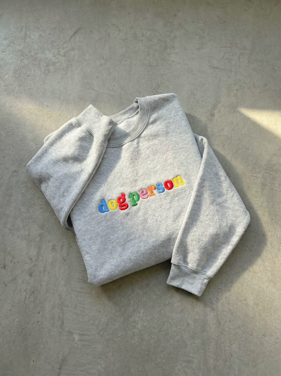 Grey Dog Person Embroidered Sweatshirt from WOOF folded, showing the stitching