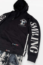 Corgi Supreme Tribute Hoodie by Dogloverclothing.com, crafted from recycled materials, features Always Smiling and an anime graphic on the front, with SMILING text down the sleeves. The bottom displays flags and text. Includes matching eco-friendly pants with an anime character design.