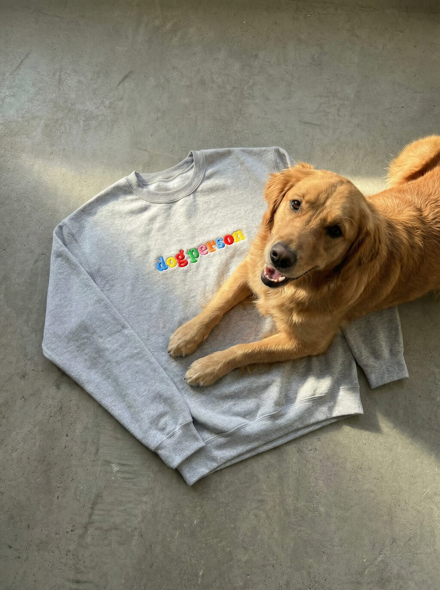 Front of the grey Dog Person Embroidered Sweatshirt from WOOF on a plain background