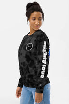 A woman with dark hair in a bun wears the Official Corgi Fan Club© Elite Camo Sweatshirt from Dogloverclothing.com. She stands sideways, looking down, and pairs the sweatshirt with blue jeans against a plain background.