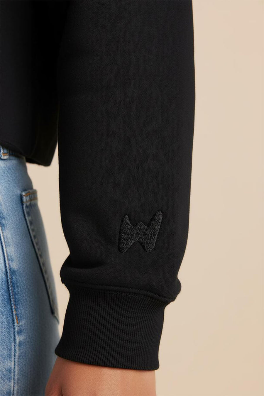Close up of the cuff and hem on the black Good Girl Crop Sweatshirt from WOOF