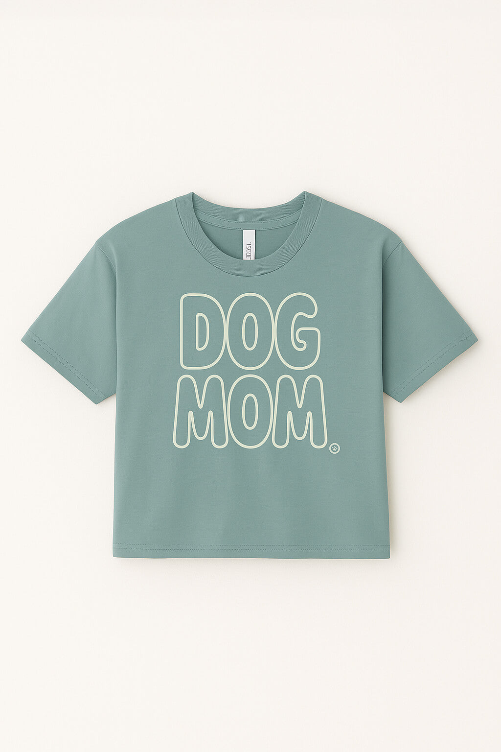 The Oversized Dog Mom Crop Top from Dogloverclothing.com is light green, made of 100% combed cotton, with a relaxed fit and bold white DOG MOM lettering on the front.