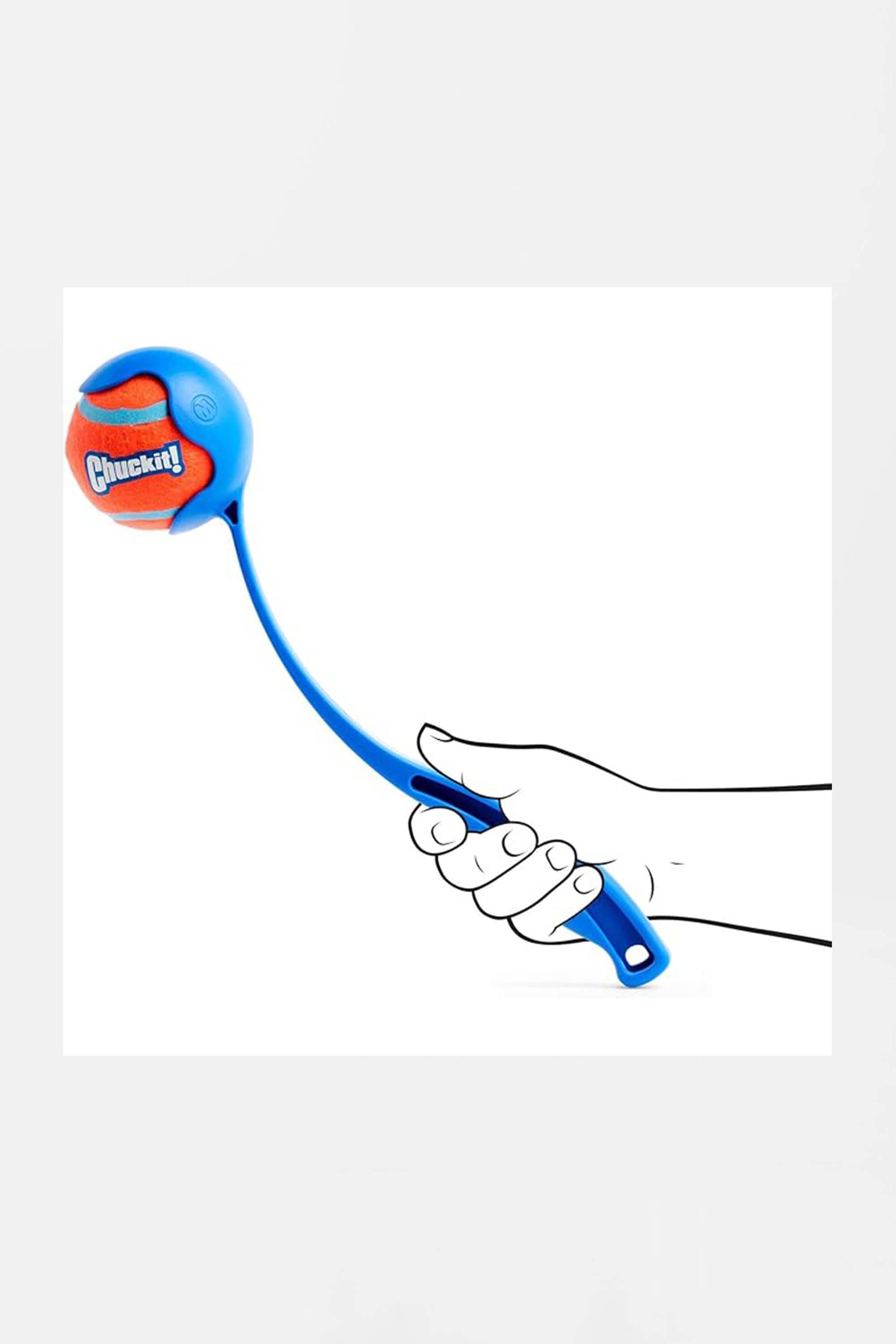 A hand holds a Chuckit! 12 Dog Ball Launcher with a red and blue ball, ideal for fetch games. Set against a plain white background, its branded by Amazon.