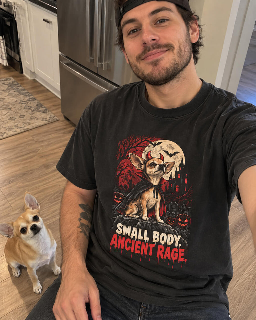 Chihuahua Halloween oversized T-shirt in Washed Black worn by a man taking a selfie at home with his Chihuahua