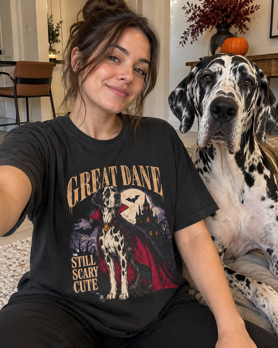 Cute Great Dane Halloween oversized T-shirt in Washed Black worn by a woman taking a selfie at home with her Harlequin Great Dane