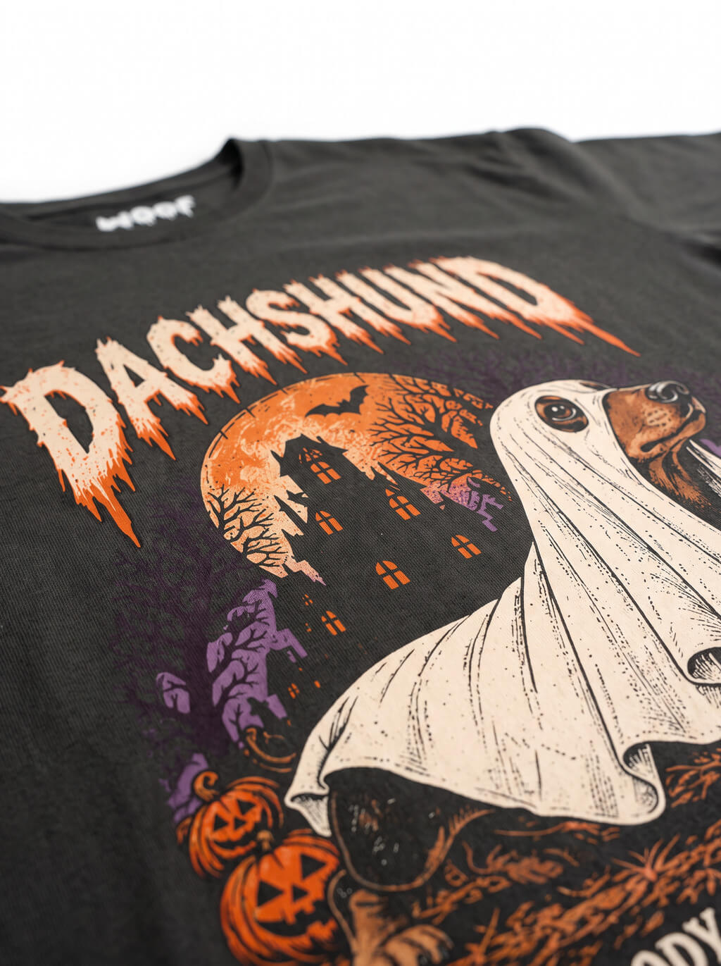 Close-up of the "Dachshund" print with a Dachshund ghost with a haunted house on the Washed Black tee
