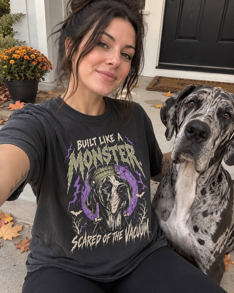 Frankenstein Great Dane oversized Halloween T-shirt in Washed Black worn by a woman taking a selfie on her porch with her Harlequin Great Dane