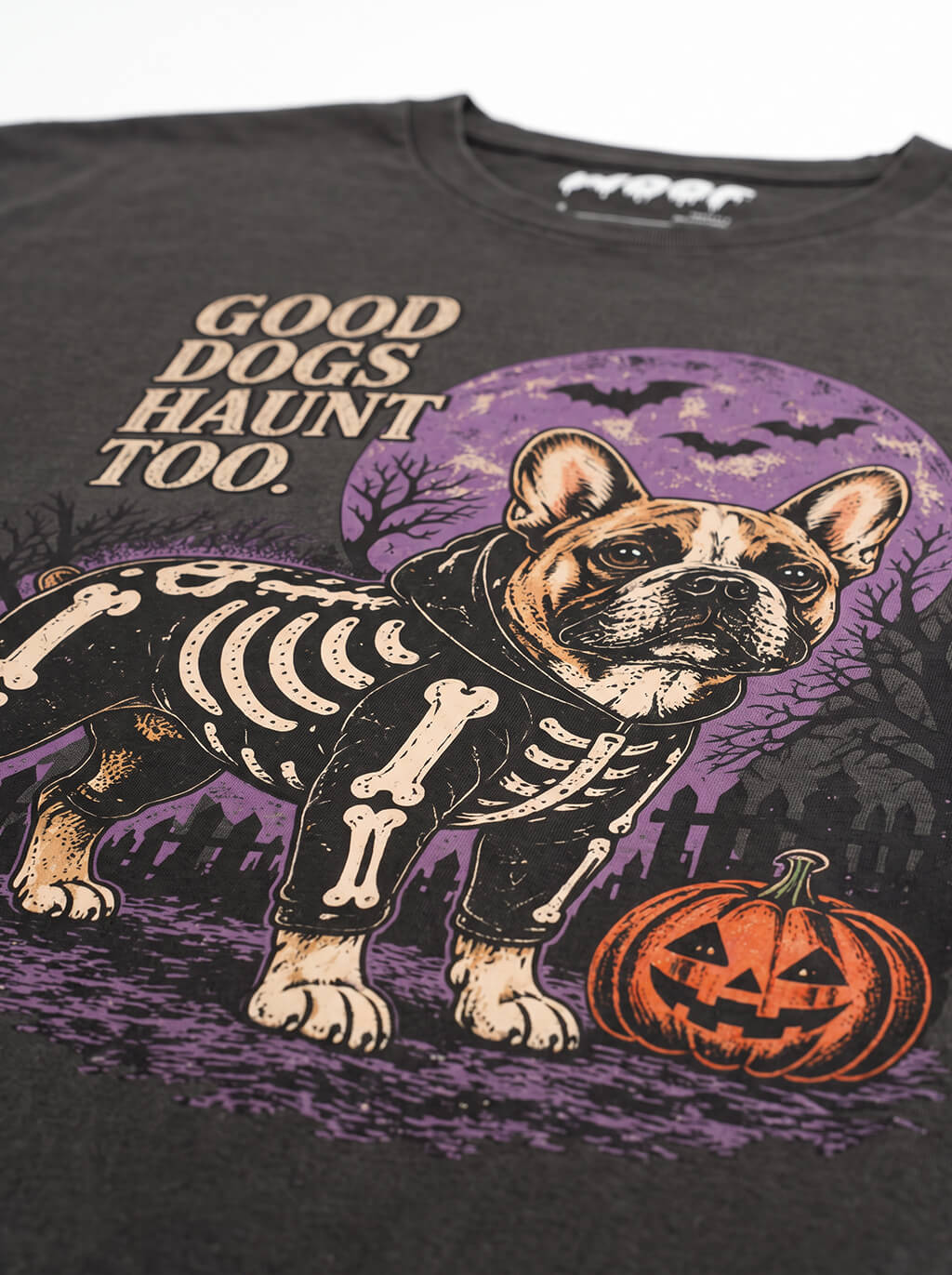 Close-up of the "Good Dogs Haunt Too" print with a skeleton French Bulldog under a full moon on the Washed Black tee