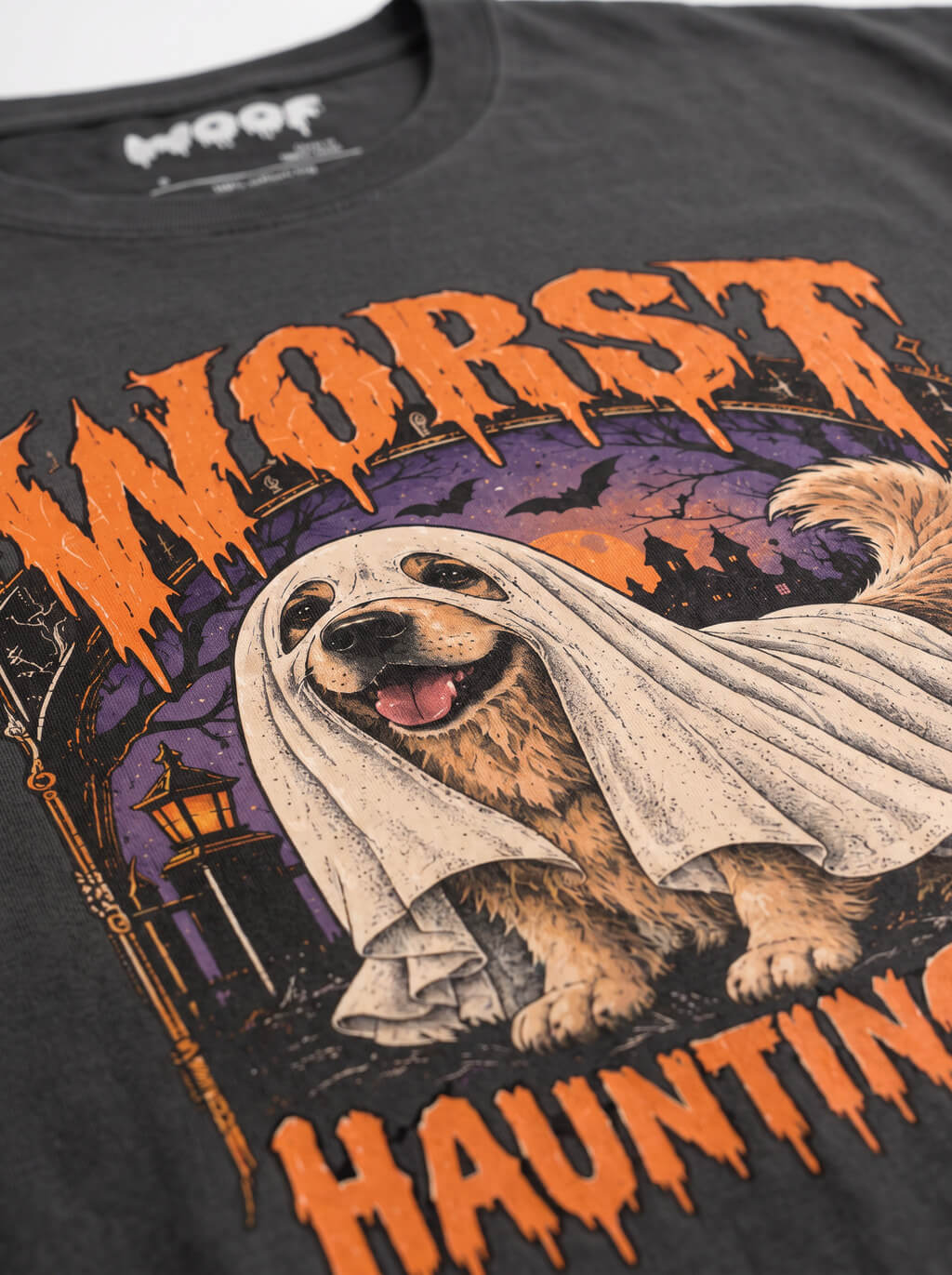 Close-up of the "Worst Haunting Ever" print with a Golden Retriever in a ghost sheet on the Washed Black tee