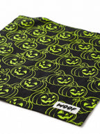 Close-up of the neon green jack-o-lantern pattern on the black Halloween dog bandana