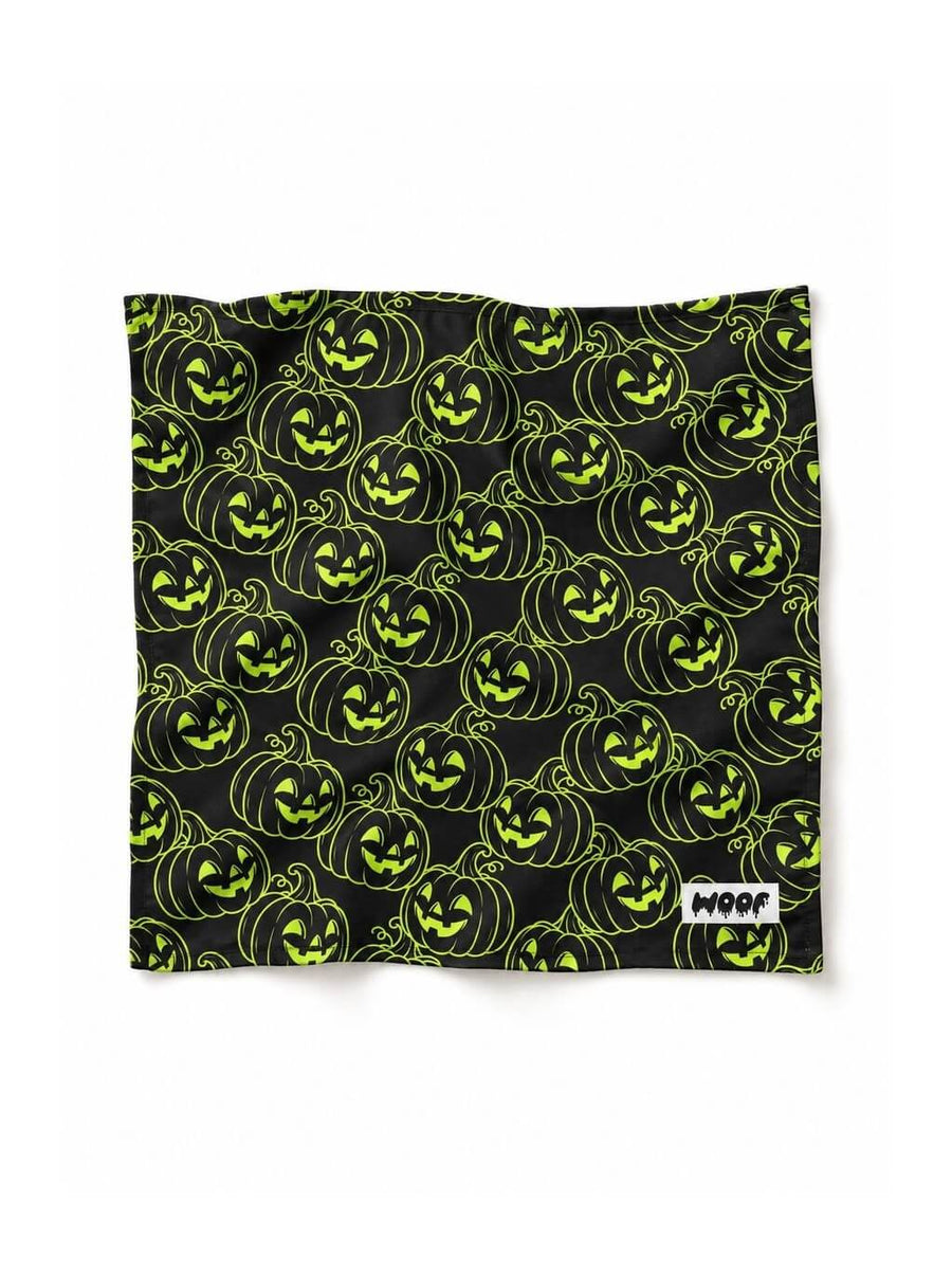 Green Pumpkin dog bandana in black with a neon green jack-o-lantern pattern, laid out flat