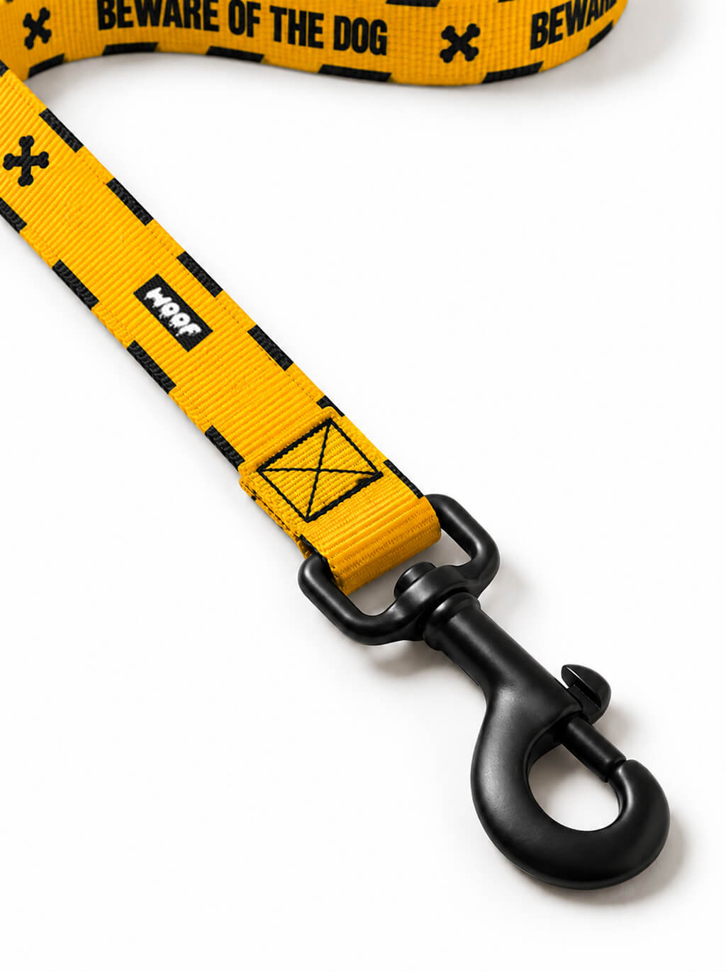 Close-up of the Haunted Hound leash handle and matte black snap hook on the yellow webbing