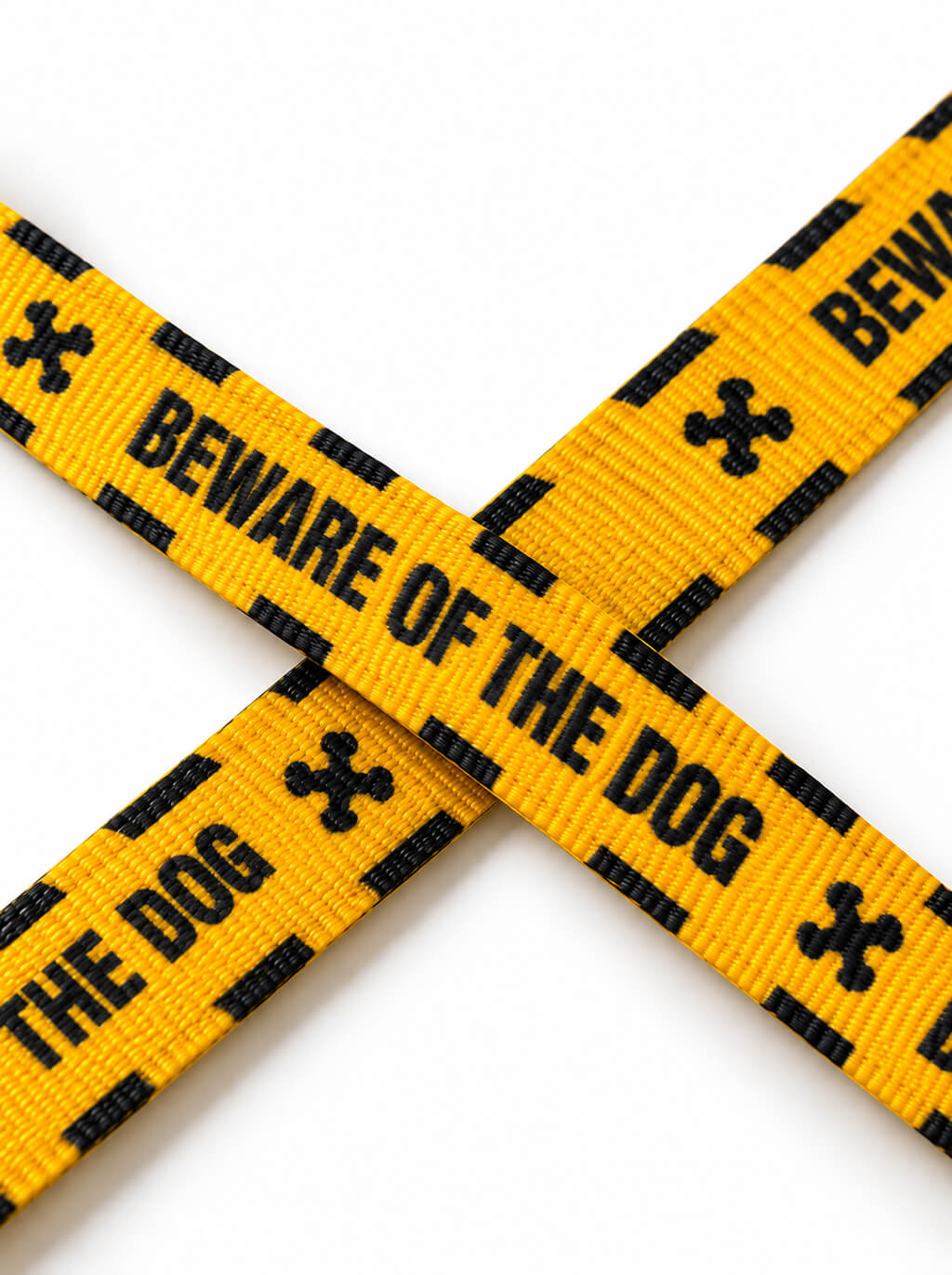 Close-up of the yellow Haunted Hound leash webbing with the black Beware of the Dog lettering and bone icons
