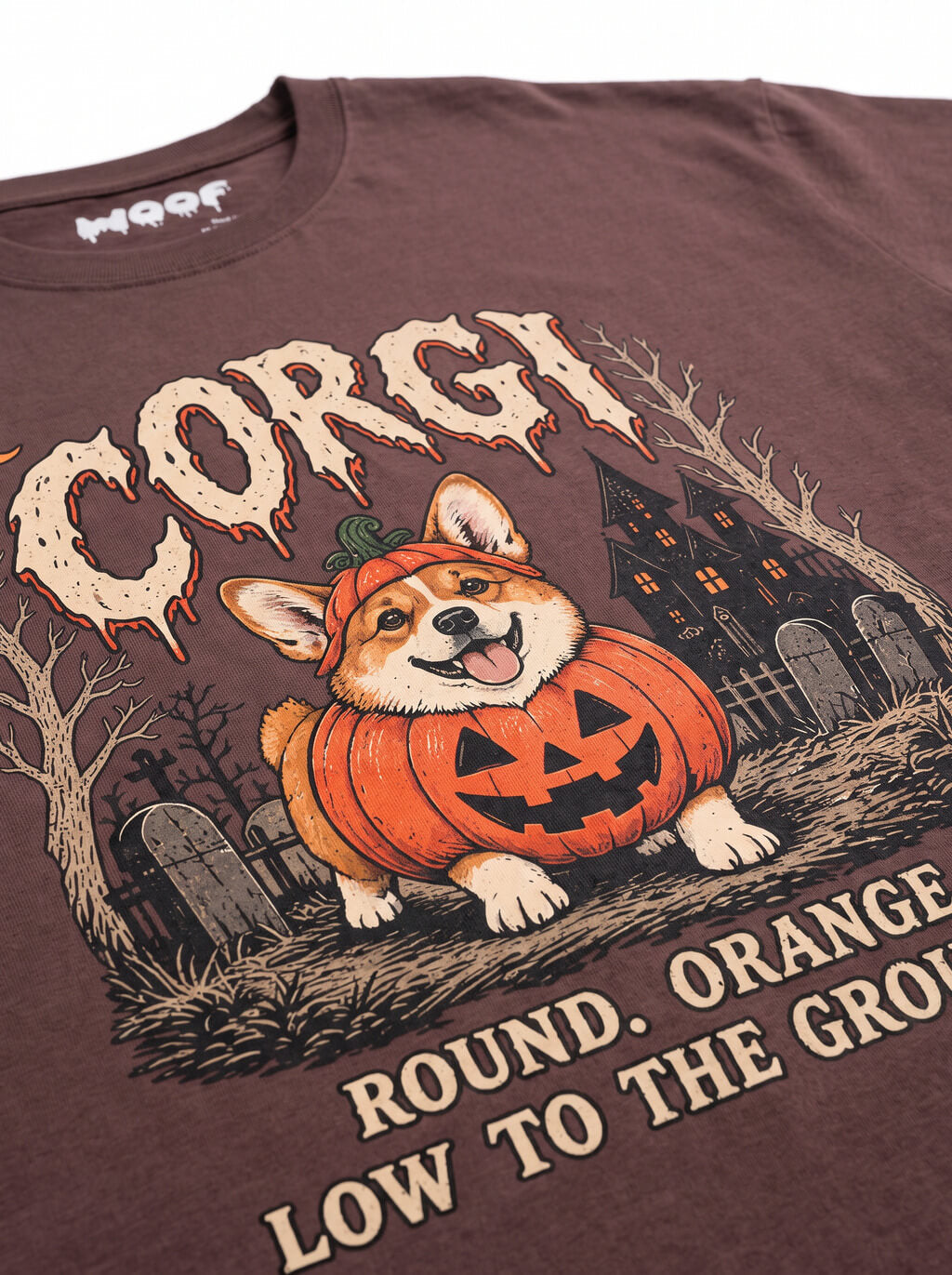 Close-up of the "Corgi – Round. Orange. Low to the Ground." print with a Corgi in a jack-o'-lantern in a graveyard on the Washed Maroon tee