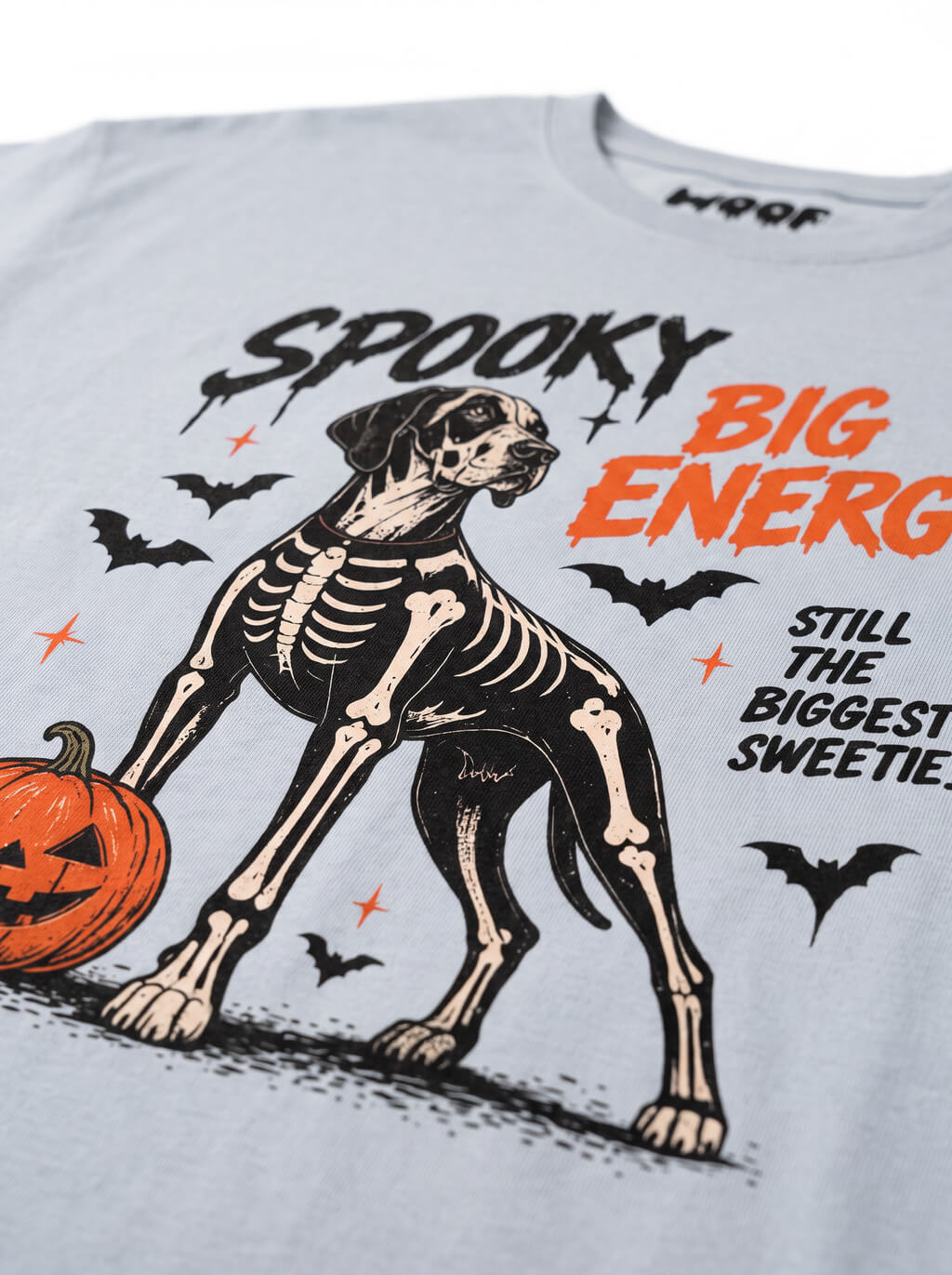 Close-up of the "Spooky Big Energy" print with a skeleton Great Dane with a pumpkin on the Light Washed Denim tee