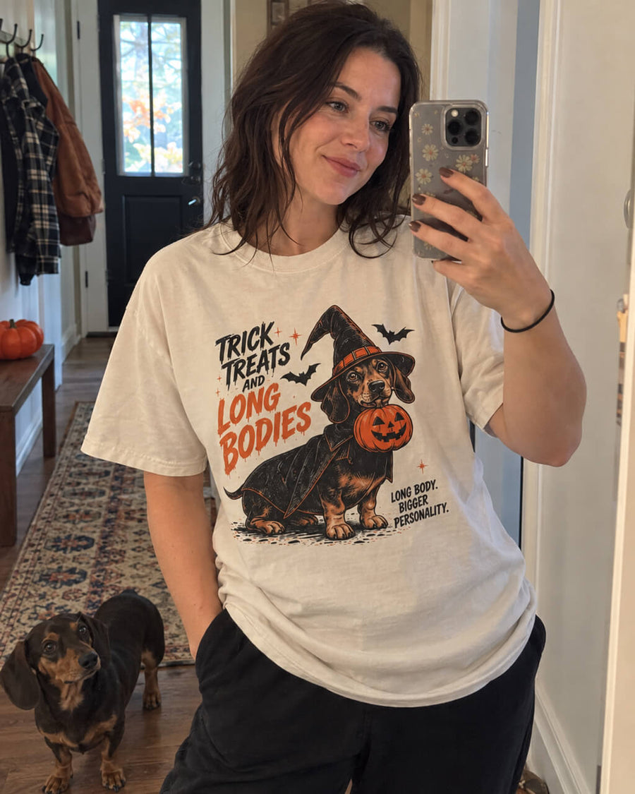 Trick or Treat Dachshund oversized Halloween T-shirt in Vintage White worn by a woman taking a mirror selfie with her Dachshund
