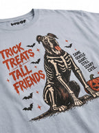 Close-up of the "Trick, Treats & Tall Friends" print with a skeleton Great Dane with a pumpkin bucket on the Light Washed Denim tee